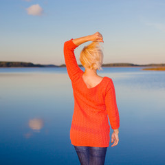 Back side view of Traveler girl watching to lake. Back of the girl in front of the lake