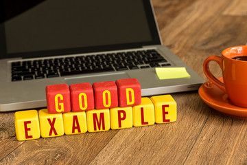 good example written on a wooden cube in a office desk