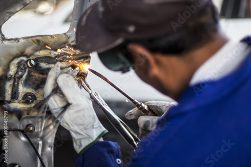 Fotografía Man mechanical worker repairing a car body in a garage