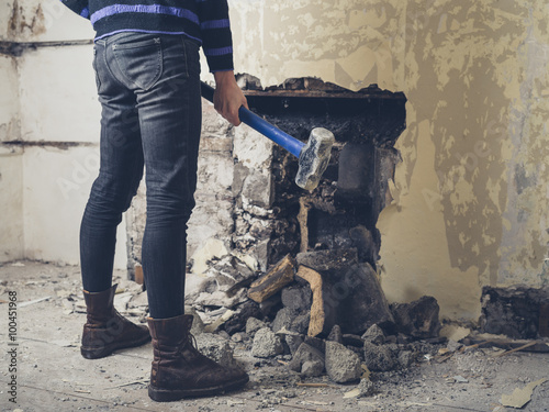 Woman Opening Up Fireplace With Sledge Hammer Buy This Stock