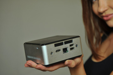 Model holding on hand  mini computer with all digital ports showing functionality