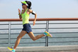© lzf - young fitness woman runner running at seaside