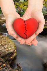 Wall Mural - Composite image of couple holding broken heart in hands