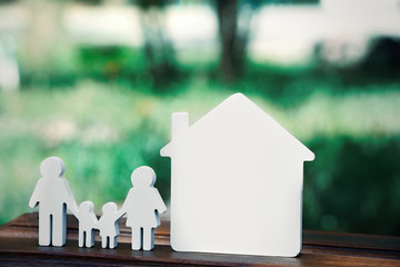 Poster - Small model of house and family on blurred background