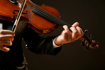 Canvas Print - Musician plays violin on black background, close up