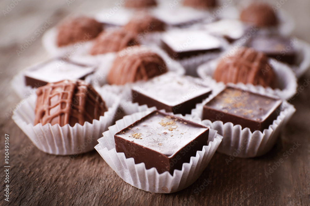 Assorted chocolate candies on wooden background