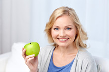 Happy Middle Aged Woman With Green Apple At Home