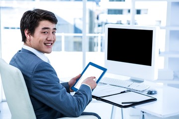 Poster - Smiling businessman using his tablet