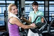 © WavebreakMediaMicro - Fit woman doing exercise bike with trainer
