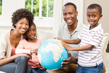 Wall Mural - Smiling family sitting on the couch together