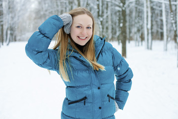 Wall Mural - Winter woman in rest snow park. Girl in a turquoise feather bed