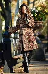 Wall Mural - Fashionable young brunette woman in elegant coat and boots at beautiful autumn alley.