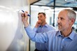 © Wavebreak Media - Businessman writing something on board