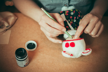 Young woman is making a doll