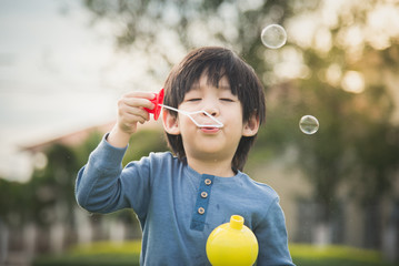 Wall Mural - sian child is blowing a soap bubbles