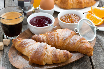 delicious breakfast with fresh croissants on wooden table