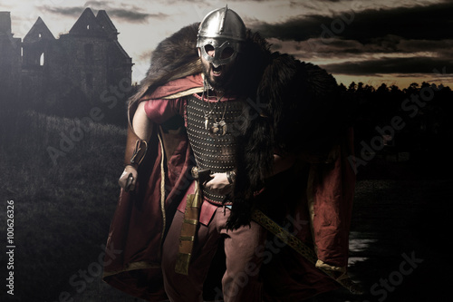 Fotografie, Obraz Křik Viking s mečem a helmou před hradní a západu slunce g