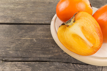 Canvas Print - Persimmon fruit on a rustic wooden background. Food series.