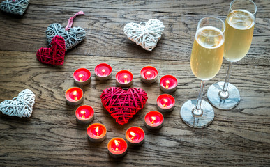 Wall Mural - Two glasses of champagne with burning candles and cane hearts