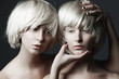 Portrait of two beautiful girls twins with closed eyes in studio, closeup