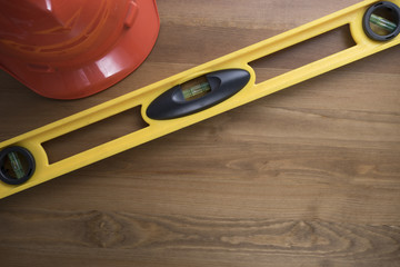 Wall Mural - Yellow building level and red helmet on the wood table