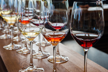 Three wine glasses with samples on wood counter