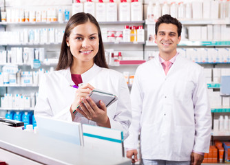 Wall Mural - Portrait of two friendly pharmacists working