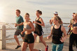 Healthy young people running together on seaside promenade