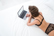 © Drobot Dean - Sexy woman in lingerie using laptop computer on the bed