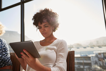 Young woman busy working on digital tablet