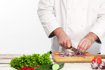 Chef cutting a onion on his kitchen