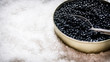 Jar with black caviar and spoon of salt.