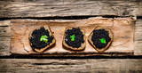 Fototapeta Kuchnia - Sandwiches with black caviar and greens .