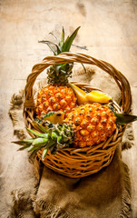 Wall Mural - Fresh pineapples in the basket. On wooden table.