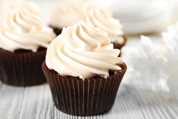 Wall Mural - White cupcakes on wooden table