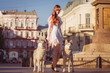 © voltgroup - Young girl walking down the street with two dogs. A girl in a white dress. Siberian Huskies.