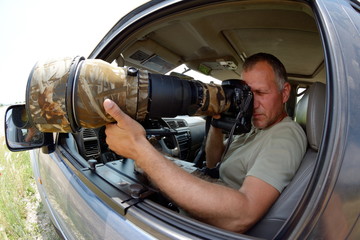 Wall Mural - wildlife photographer sitting in the car