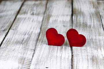 Wall Mural - Two red wooden hearts on white rustic wood background