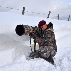 Wall Mural - professional photographer outdoor in winter on harsh weather