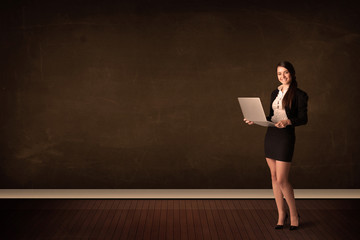 Poster - Businesswoman holding high tech laptop on background with copysp