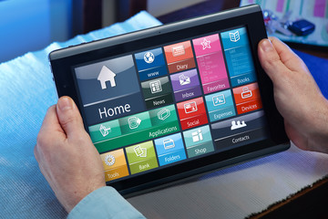 man working with the software of tablet pc at home / businessman in the office holding a tablet and 