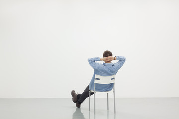 Wall Mural - Man sitting on a chair in white room