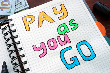 Pay as you go PAYG written on a notebook. Business concept.