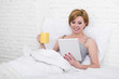 © Wordley Calvo Stock - attractive woman on bed using digital tablet pad reading morning online news in internet having coffee