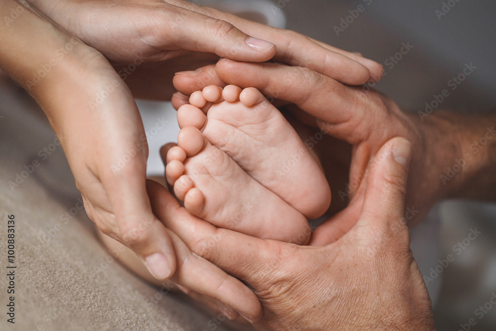 Children's feet in hands of mother and father. - obrazy, fototapety, plakaty 