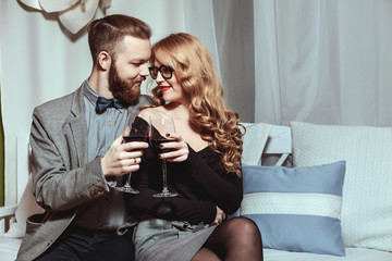 Wall Mural - Beautiful young couple with glasses of red wine in luxury restaurant