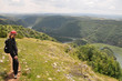 © mastermilmar - Young woman hiking in nature and looking the scenic view of River Uvac on a sunny summer day