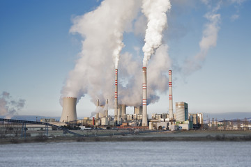 A coal-fired power station in the distance in agricultural landscape. Pocerady, Czech republic