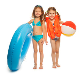 Two little swimmers with rubber ring and wind-ball