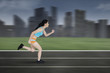 © Creativa Images - Female runner running on a track